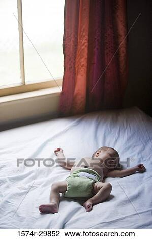 Stock Image - Newborn baby sleeping on the bed. Fotosearch