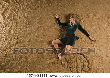 Overhead view of a young woman lying on sand View Large Photo Image Stock Image - Overhead view of a young woman lying on sand. Fotosearch