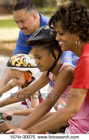 Parents helping their children to ride bicycles on the road View Large Photo Image Stock Image - Parents helping their children to ride bicycles on the road. Fotosearch