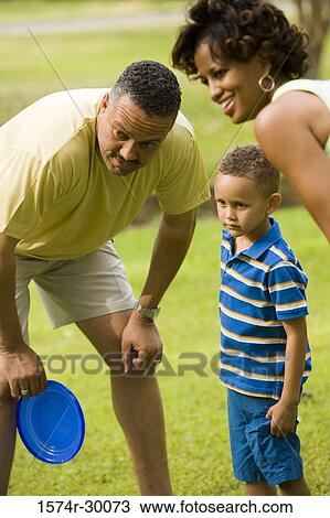 Parents playing plastic disk with their son at park View Large Photo Image Stock Image - Parents playing plastic disk with their son at park. Fotosearch