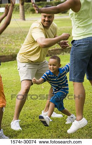 Picture - Parents playing with their children at park. Fotosearch