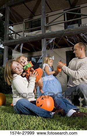 Stock Photo - Parents playing with their children in front of a house. Fotosearch