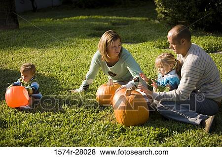 Stock Photo - Parents playing with their children on grass. Fotosearch