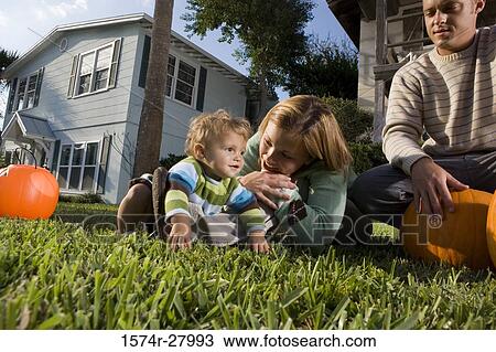Parents playing with their son in front of a house View Large Photo Image Stock Image - Parents playing with their son in front of a house. Fotosearch