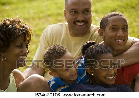 Stock Photograph - Parents smiling with their children at park. Fotosearch