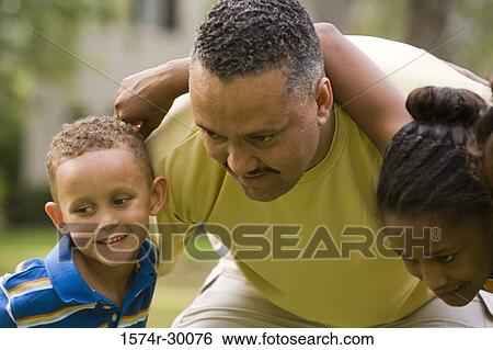 Stock Photograph - Parents standing with their son at park. Fotosearch