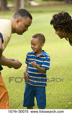 Parents standing with their son at park View Large Photo Image Stock Photography - Parents standing with their son at park. Fotosearch