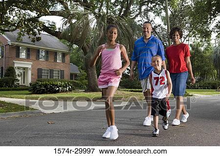 Stock Photo - Parents walking with their children on the road. Fotosearch