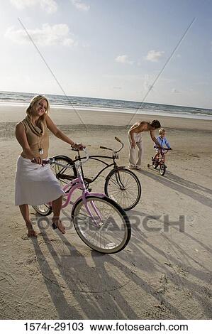 Parents with son riding cycle at the beach View Large Photo Image Stock Image - Parents with son riding cycle at the beach. Fotosearch