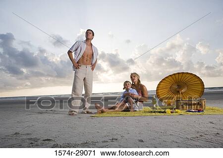 Stock Image - Parents with their son at the beach. Fotosearch