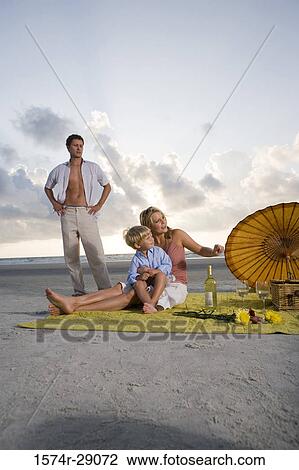 Stock Image - Parents with their son at the beach. Fotosearch