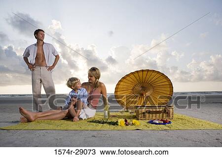 Stock Image - Parents with their son at the beach. Fotosearch