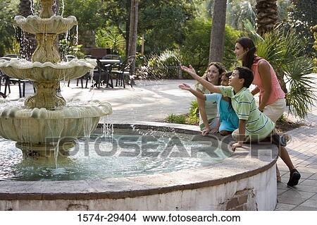People sitting together by a water fountain View Large Photo Image Picture - People sitting together by a water fountain. Fotosearch