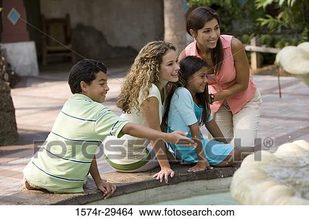 Picture - People sitting together by a water fountain. Fotosearch
