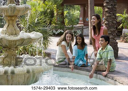 People sitting together by a water fountain View Large Photo Image Stock Image - People sitting together by a water fountain. Fotosearch