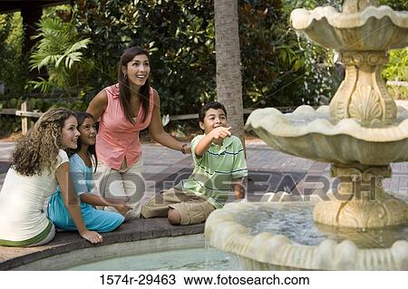 People sitting together by a water fountain View Large Photo Image Stock Image - People sitting together by a water fountain. Fotosearch
