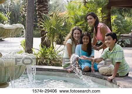 People sitting together by a water fountain View Large Photo Image Stock Photograph - People sitting together by a water fountain. Fotosearch