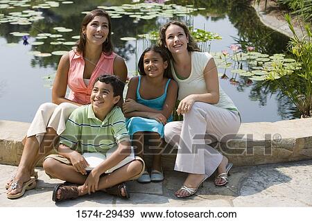 People sitting together by pond and smiling View Large Photo Image Stock Photo - People sitting together by pond and smiling. Fotosearch