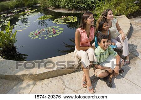 People sitting together by pond and smiling View Large Photo Image Stock Photograph - People sitting together by pond and smiling. Fotosearch