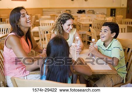Stock Image - People sitting together on chairs by table in hotel. Fotosearch