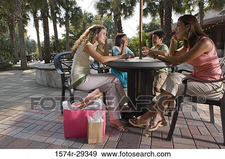 People sitting together on chairs by table View Large Photo Image Stock Photo - People sitting together on chairs by table. Fotosearch