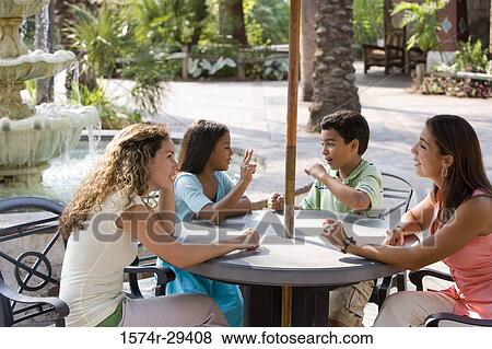 People sitting together on chairs by table View Large Photo Image Stock Photo - People sitting together on chairs by table. Fotosearch