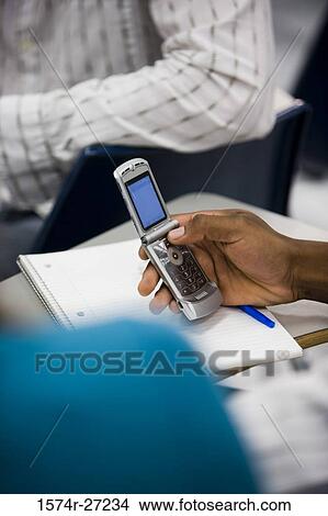 Person using a mobile phone in the classroom View Large Photo Image Picture - Person using a mobile phone in the classroom. Fotosearch