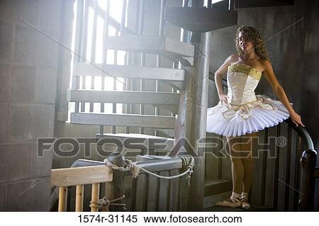 Stock Photography - Portrait of a ballet dancer standing on a spiral wooden staircase. Fotosearch