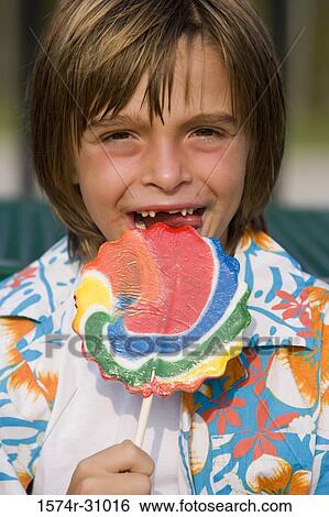 Portrait of a boy eating lollipop View Large Photo Image Stock Photograph - Portrait of a boy eating lollipop. Fotosearch