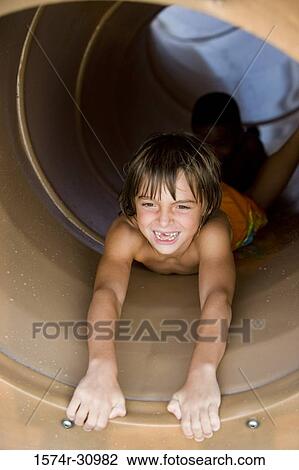 Portrait of a boy sliding in tunnel slide View Large Photo Image Stock Image - Portrait of a boy sliding in tunnel slide. Fotosearch