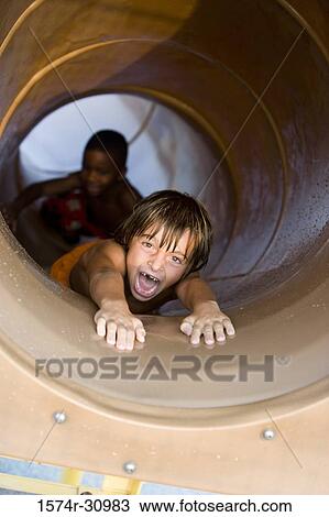 Portrait of a boy sliding in tunnel slide View Large Photo Image Stock Image - Portrait of a boy sliding in tunnel slide. Fotosearch