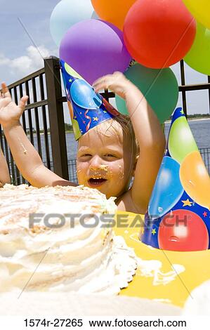 Stock Photography - Portrait of a boy smiling in front of a birthday cake. Fotosearch
