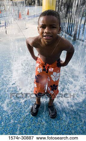 Portrait of a boy standing under a shower View Large Photo Image Stock Photo - Portrait of a boy standing under a shower. Fotosearch