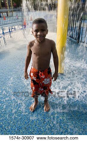 Portrait of a boy standing under a shower View Large Photo Image Stock Photo - Portrait of a boy standing under a shower. Fotosearch