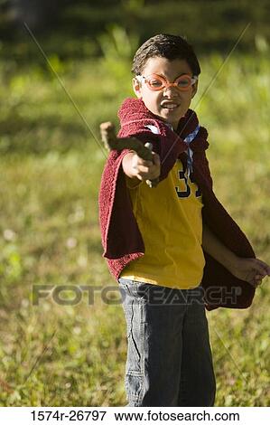 Portrait of a boy wearing a towel and swimming goggles holding a stick at forest View Large Photo Image Stock Photo - Portrait of a boy wearing a towel and swimming goggles holding a stick at forest. Fotosearch