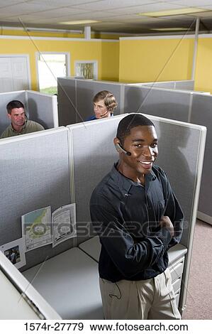 Portrait of a businessman leaning by desk while colleagues conversing in the background View Large Photo Image Stock Photo - Portrait of a businessman leaning by desk while colleagues conversing in the background. Fotosearch