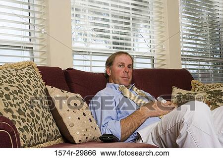 Portrait of a businessman relaxing on a sofa View Large Photo Image Stock Photograph - Portrait of a businessman relaxing on a sofa. Fotosearch