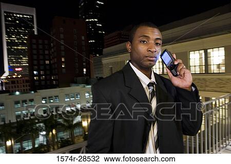 Portrait of a businessman standing in a balcony and using a mobile phone View Large Photo Image Stock Image - Portrait of a businessman standing in a balcony and using a mobile phone. Fotosearch