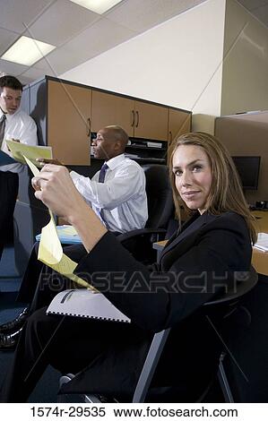 Portrait of a businesswoman holding papers while colleagues in background View Large Photo Image Stock Photography - Portrait of a businesswoman holding papers while colleagues in background. Fotosearch