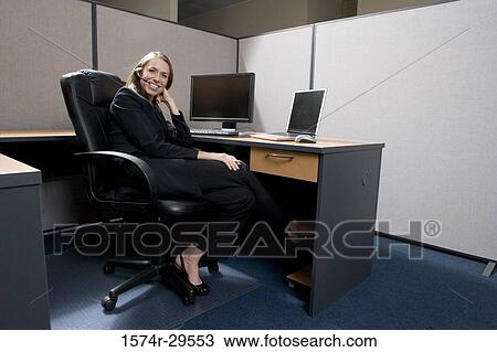 Portrait of a businesswoman sitting in front of computer in an office View Large Photo Image Stock Image - Portrait of a businesswoman sitting in front of computer in an office. Fotosearch
