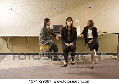 Portrait of a businesswoman sitting in front of colleagues discussing View Large Photo Image Stock Photo - Portrait of a businesswoman sitting in front of colleagues discussing. Fotosearch