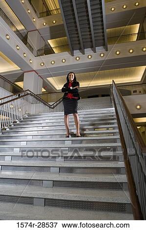 Portrait of a businesswoman standing on staircase in an office View Large Photo Image Stock Photo - Portrait of a businesswoman standing on staircase in an office. Fotosearch