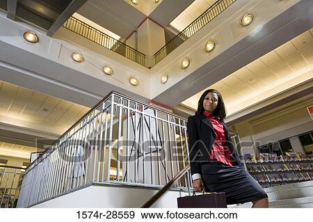 Portrait of a businesswoman standing on staircase in an office View Large Photo Image Stock Photo - Portrait of a businesswoman standing on staircase in an office. Fotosearch