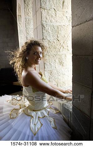 Stock Photo - Portrait of a cheerful ballet dancer standing by window. Fotosearch
