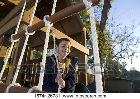 Portrait of a cheerful boy holding a rope at forest View Large Photo Image Stock Image - Portrait of a cheerful boy holding a rope at forest. Fotosearch