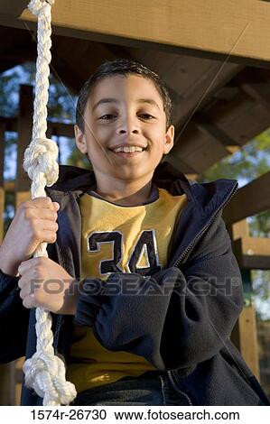 Stock Image - Portrait of a cheerful boy playing with a rope. Fotosearch