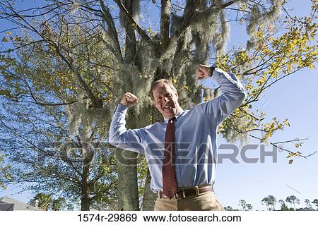 Portrait of a cheerful businessman flexing muscles View Large Photo Image Stock Photo - Portrait of a cheerful businessman flexing muscles. Fotosearch