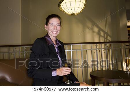 Portrait of a cheerful businesswoman with wineglass sitting on armchair View Large Photo Image Stock Photo - Portrait of a cheerful businesswoman with wineglass sitting on armchair. Fotosearch