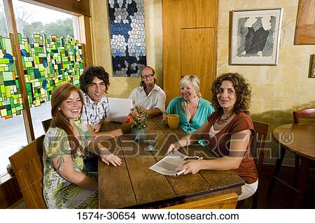 Picture - Portrait of a cheerful family sitting together by table. Fotosearch