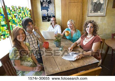 Portrait of a cheerful family sitting together by table View Large Photo Image Stock Photography - Portrait of a cheerful family sitting together by table. Fotosearch